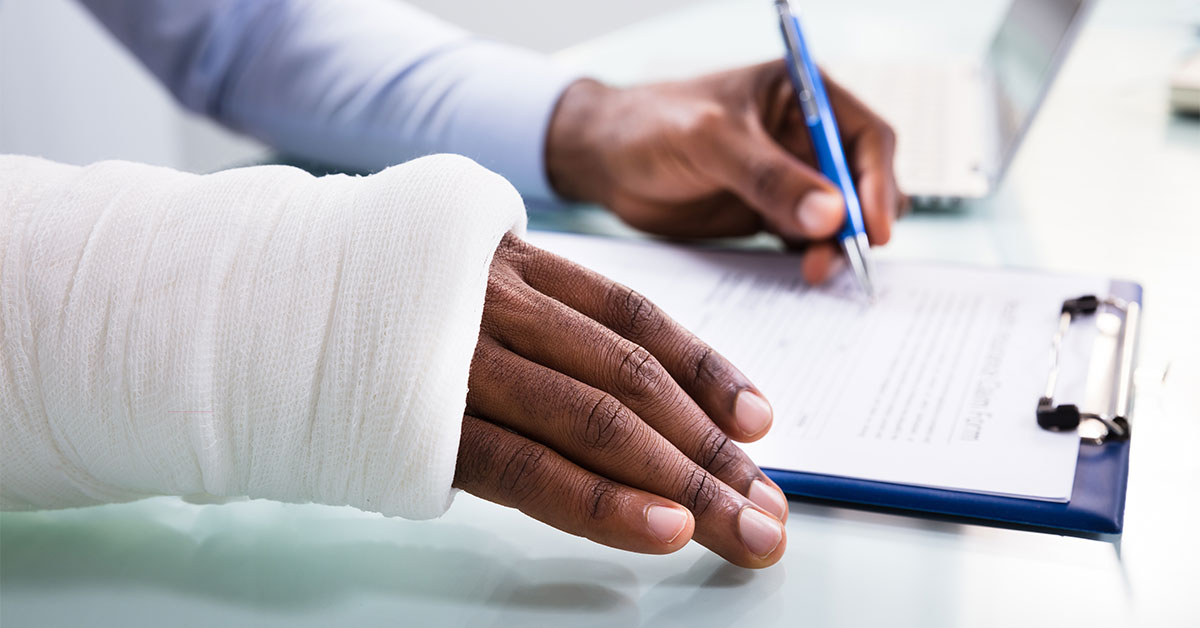 man with cast signing paperwork